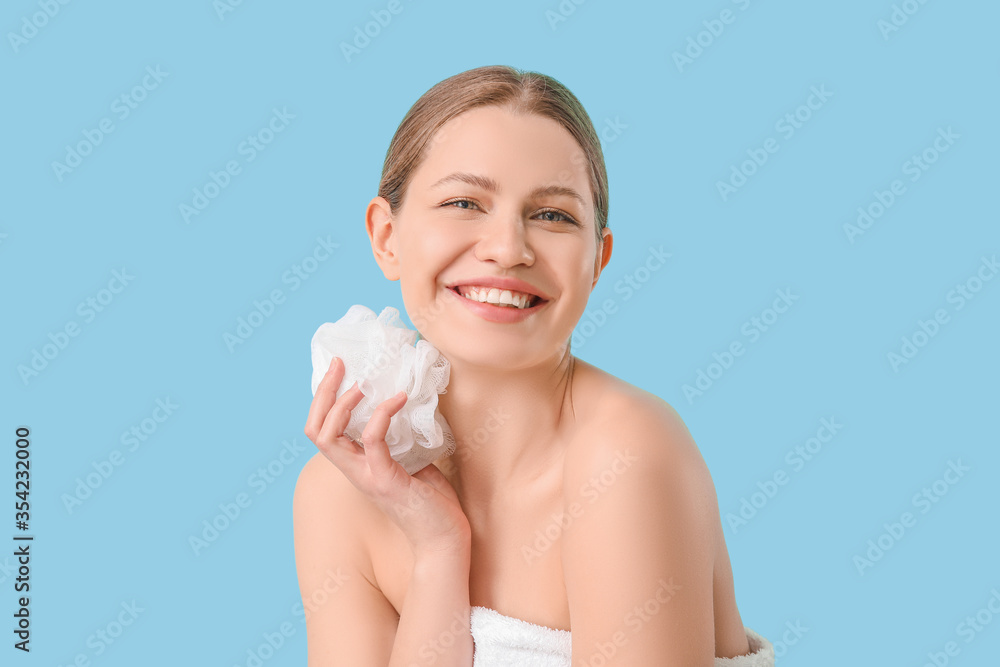 Beautiful young woman taking shower on color background
