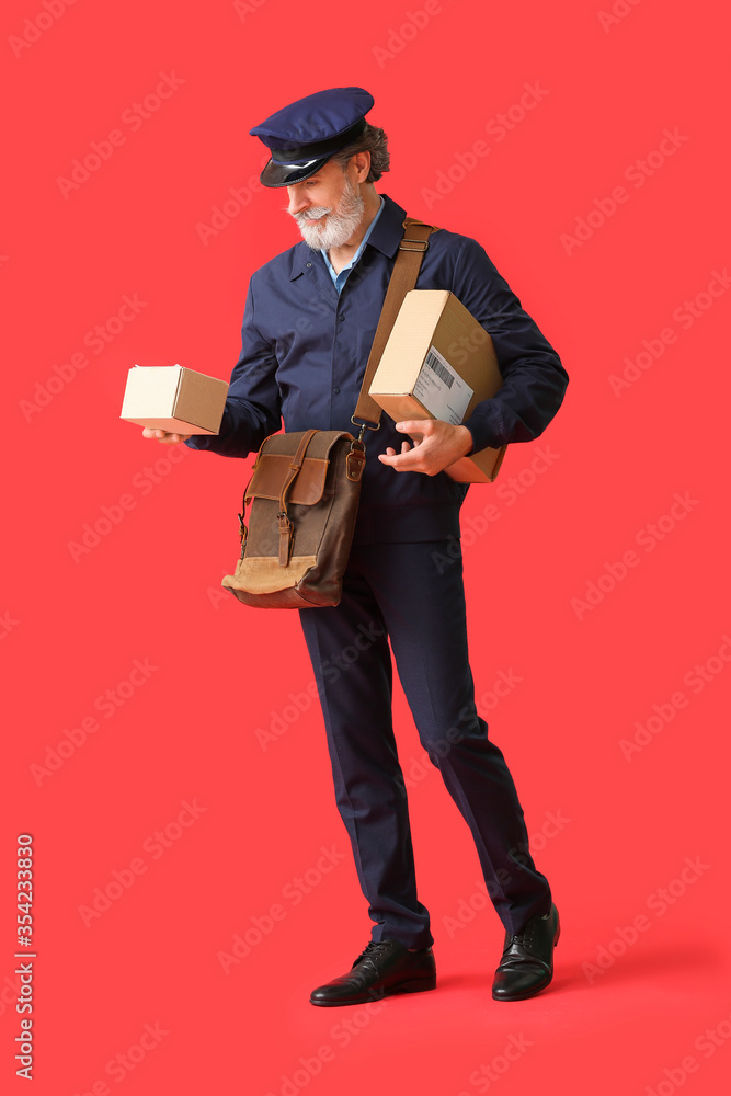 Handsome old postman on color background