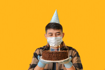 Canvas Print - Asian man in protective mask and with Birthday cake on color background. Concept of epidemic