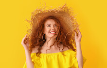 Portrait Of Beautiful Redhead Woman In Straw Hat On Color Background
