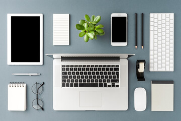 office desktop with laptop and business accessories on gray background. modern workspace concept. to