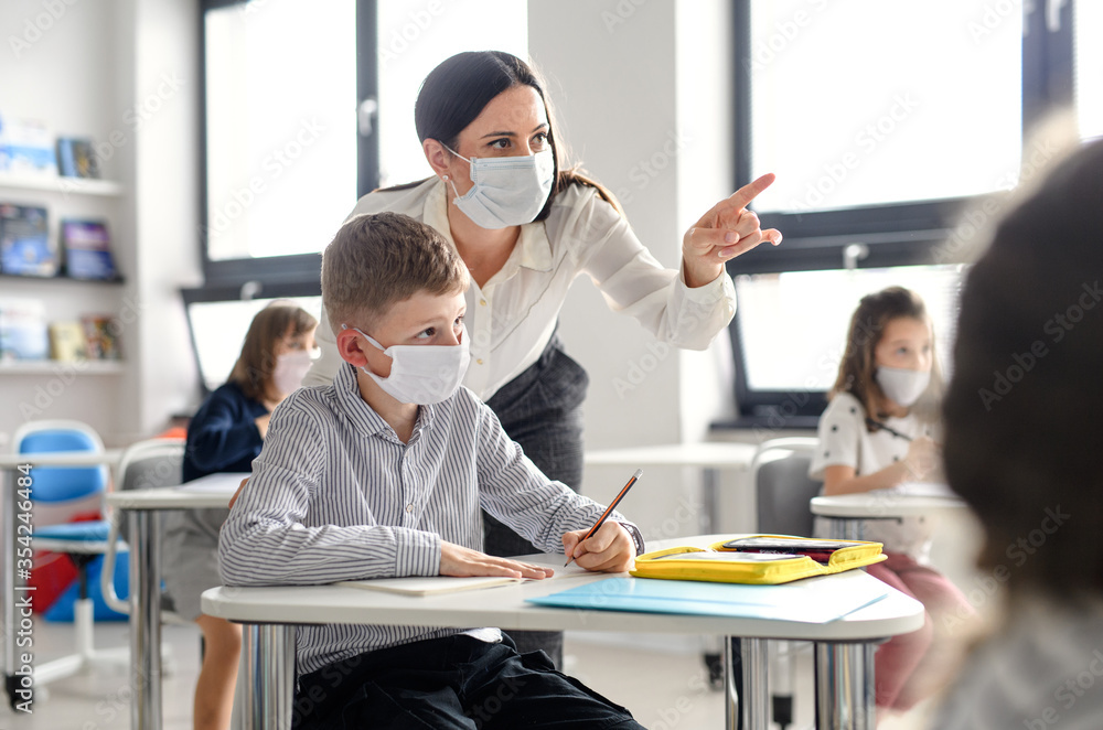 Teacher and children with face mask back at school after covid-19 quarantine and lockdown. - obrazy, fototapety, plakaty 
