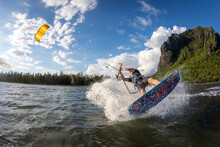 Professional Kiter Makes The Difficult Trick On A Beautiful Background Of Spray And Beautiful Mountains Of Mauritius