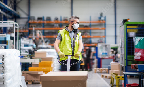 Cuadros en Lienzo Man worker with protective mask working in industrial factory or warehouse