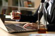 © PheelingsMedia - Entrepreneur hands drinking alcohol working on laptop at homeoffice