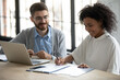 © fizkes - Smiling African American woman signing contract at meeting with manager, sitting at table, satisfied customer making great deal, successful candidate putting signature on job agreement