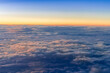 Panorama view of fluffy clouds on sunset sky view from flying airplane