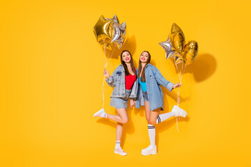 Sticker - Full length body size view of nice attractive lovely slender cheerful cheery girls holding in hands air balls dancing having fun isolated on bright vivid shine vibrant yellow color background