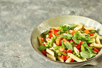 Poster - salad in a bowl of pasta, asparagus, bean pods, tomatoes, green peas, basil.