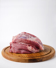 Fresh raw pork ham on the wooden cutting board, white background