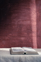 Aufkleber - Open Holy Bible on a table. Beautiful red wall background..