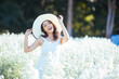 © uinmine - Young beautiful woman in a white dress posing in white flower garden