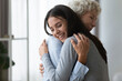 © fizkes - Grown up adult smiling 20s granddaughter embraces elderly grandmother glad to see missing her, visit of loving relatives enjoy communication, cuddle as symbol of connection, love and support concept