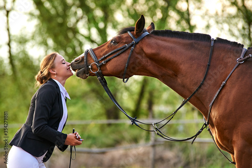 Cuadros en Lienzo Horse rider girl and horse on a farm. horse kisses a girl.