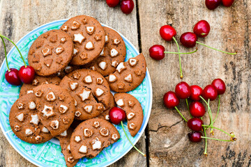 Wall Mural -   Cherries and cocoa cookies with  vanilla star decoration on wooden background. Summer dessert