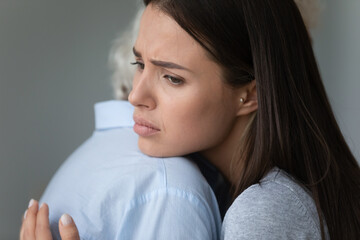 Wall Mural - Close up image sad face of grown up loving daughter cuddles strokes elderly mother showing her care express sympathy share life troubles and pain, warm relations, apologize or reconciliation concept