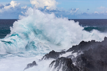  A big wave is crashing over a black rocks of volcanic coastline of Atlantic ocean on Tenerife island, Canary Islands, Spain