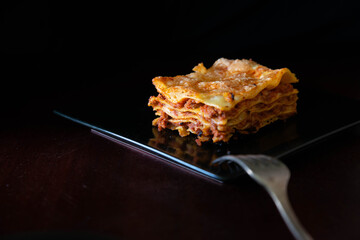 Close-up of a traditional lasagna made with minced beef bolognese sauce topped. Low light.