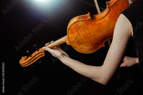 Obrazy filharmonia  przyciety-widok-profesjonalnej-kobiety-grajacej-na-skrzypcach-na-ciemnej-scenie
