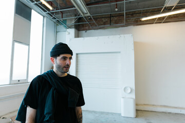 Portrait of relaxed young fashionable skater man in black outfit