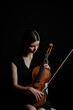 beautiful female musician holding violin isolated on black