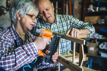 Wall Mural - Senior couple working in a carpentry workshop