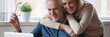© fizkes - 60s wife hug husband spouses looking at pc screen read good news. Make videocall talk with grownup children, receive great offer eyewear sale concept. Horizontal photo banner for website header design
