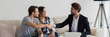 © fizkes - Happy couple young family flat renters shake hands with realtor seated on sofa in living room. Make real estate deal, first dwelling purchase concept. Horizontal photo banner for website header design