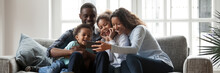 Full African Family With Little Kids Sit On Couch In Living Room Having Fun Using Smart Phone New Cool Application, Taking Selfie, Watch Funny Videos. Horizontal Photo Banner For Website Header Design