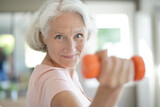 Fototapeta  - Portrait of senior woman lifting dumbbells, fitness exercices