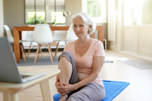 Senior Woman Doing Fitness Exercises At Home Through Virtual Class