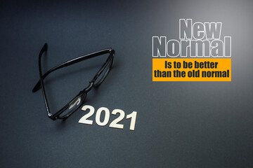 Eyeglasses with block letters on black background with a message on new normal