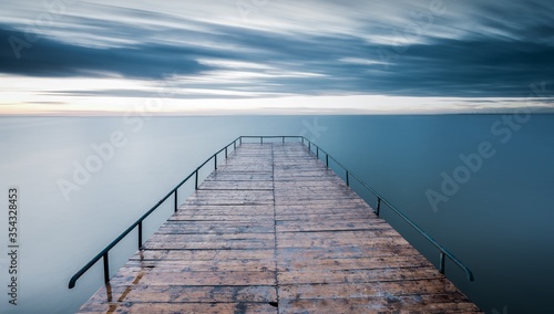 Cuadros en Lienzo Empty wooden pier over blue sea with a sky background