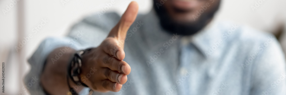 Close up African agent reach out hand to camera handshake client. Make deal, company boss HR recruiter greet applicant starting job interview concept. Horizontal photo banner for website header design - obrazy, fototapety, plakaty 