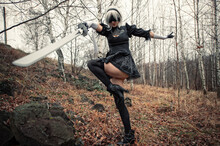 Cosplay Beautiful Woman In The Forest With Black Dress And With Sword