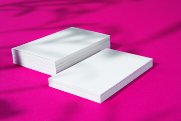 Advertising mock-up. White blank businesscards on bright pink background