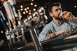 © BGStock72 - Man drinking beer and smoking cigarette at pub in the night club