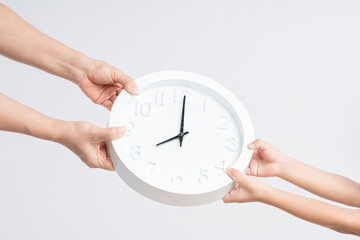 Adult pulling or sharing clock again kid hands as time consuming in family concept