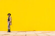 © VISTA by Westend61 - Young man dancing in front of yellow wall