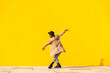 © VISTA by Westend61 - Young man dancing in front of yellow wall