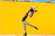 © VISTA by Westend61 - Young man dancing in front of yellow wall
