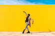 © VISTA by Westend61 - Young man dancing in front of yellow wall, taking selfies