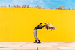 © VISTA by Westend61 - Young man dancing in front of yellow wall