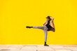 © VISTA by Westend61 - Young man dancing in front of yellow wall