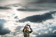 © VISTA by Westend61 - Man posing dressed as an astronaut on a meadow with dramatic clouds in the background