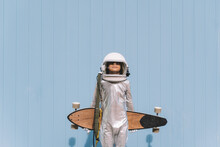 Kid Dressed As An Astronaut With Longboard