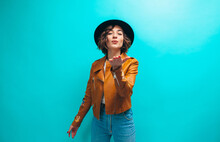 Fashion Portrait Of Young Stylish Hipster Woman Wearing Trendy Brown Leather Jacket, Black Hat, Blue Denim Jeans And White Blank T-shirt . Crazy Emotions