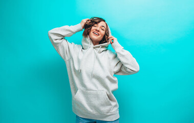 Wall Mural - Portrait of handsome hipster girl wearing gray blank hoodie or hoody with space for your logo or design. Mockup for print.