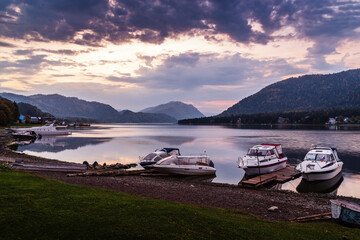 Wall Mural - Lake shore with moored motor boats at dawn. Teletskoye Lake, Artybash Village, Altai Republic, Russia