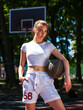 © Andrey_Arkusha - Young woman with a basketball ball posing on the playground
